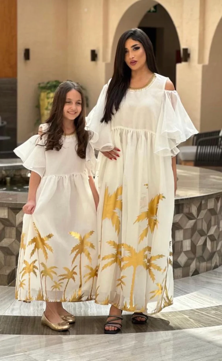 فستان ابيض بطبعات ذهبية على شكل نخيل