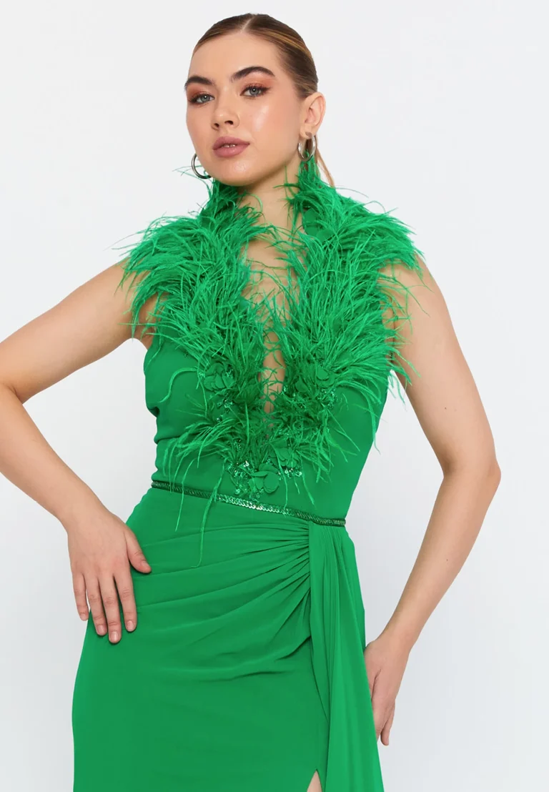 فستان أخضر طويل بفتحة جانبية وتصميم مزين بالريش