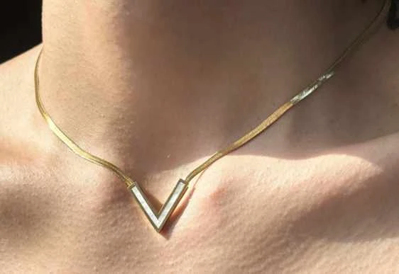 عقد باللون الذهبي بتصميم حرف V مقلوب